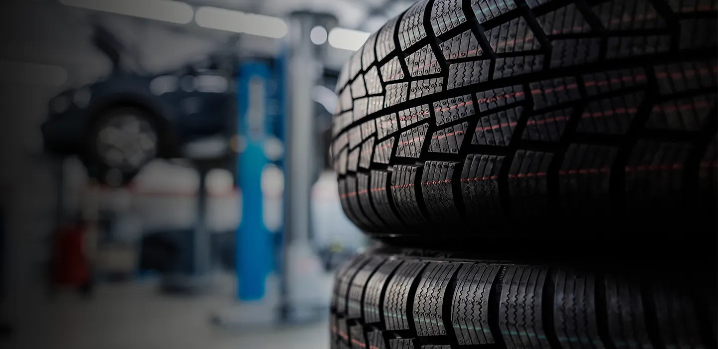 Stack of tires in a garage setting with blurred background